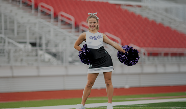 Cheerleader wearing Champion Stock Uniform holding poms poms