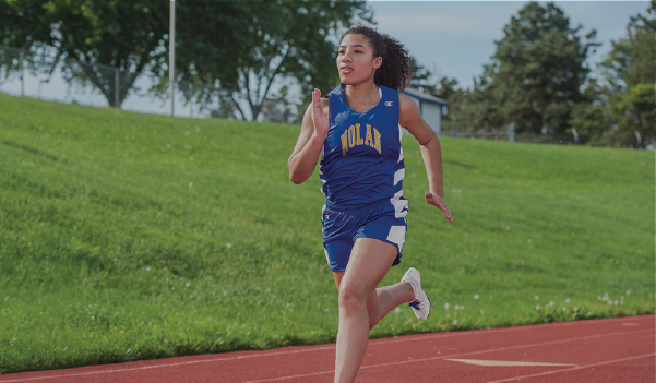 Male Athlete Jumping Hurdles Wearing Champion Track Stock Uniforms